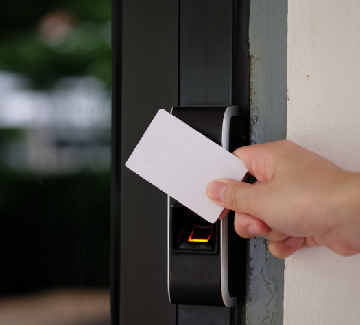 A hand holding a card to open a keypad giving them access control